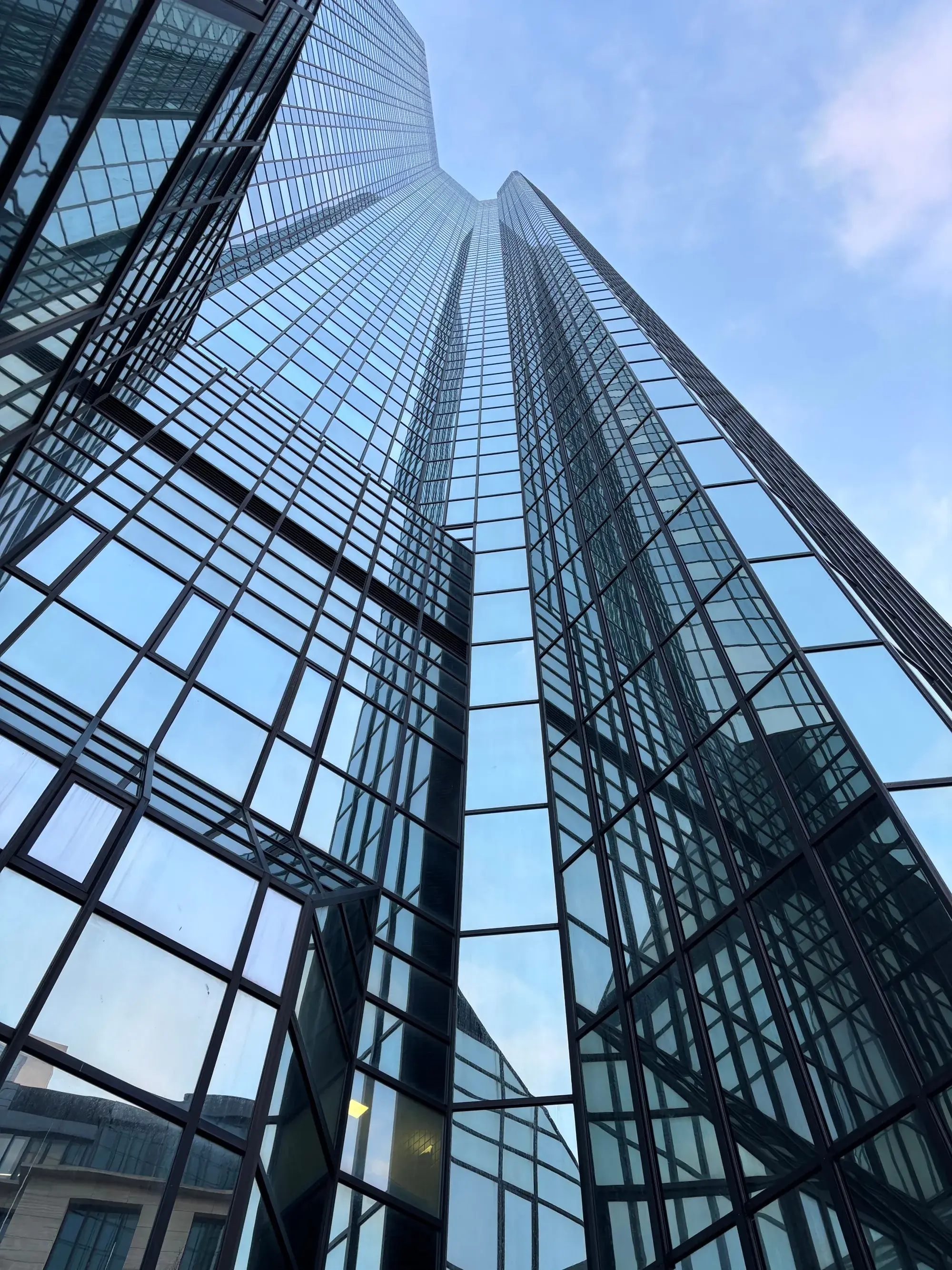 Close-up view of a modern glass tower facade reflecting the sky