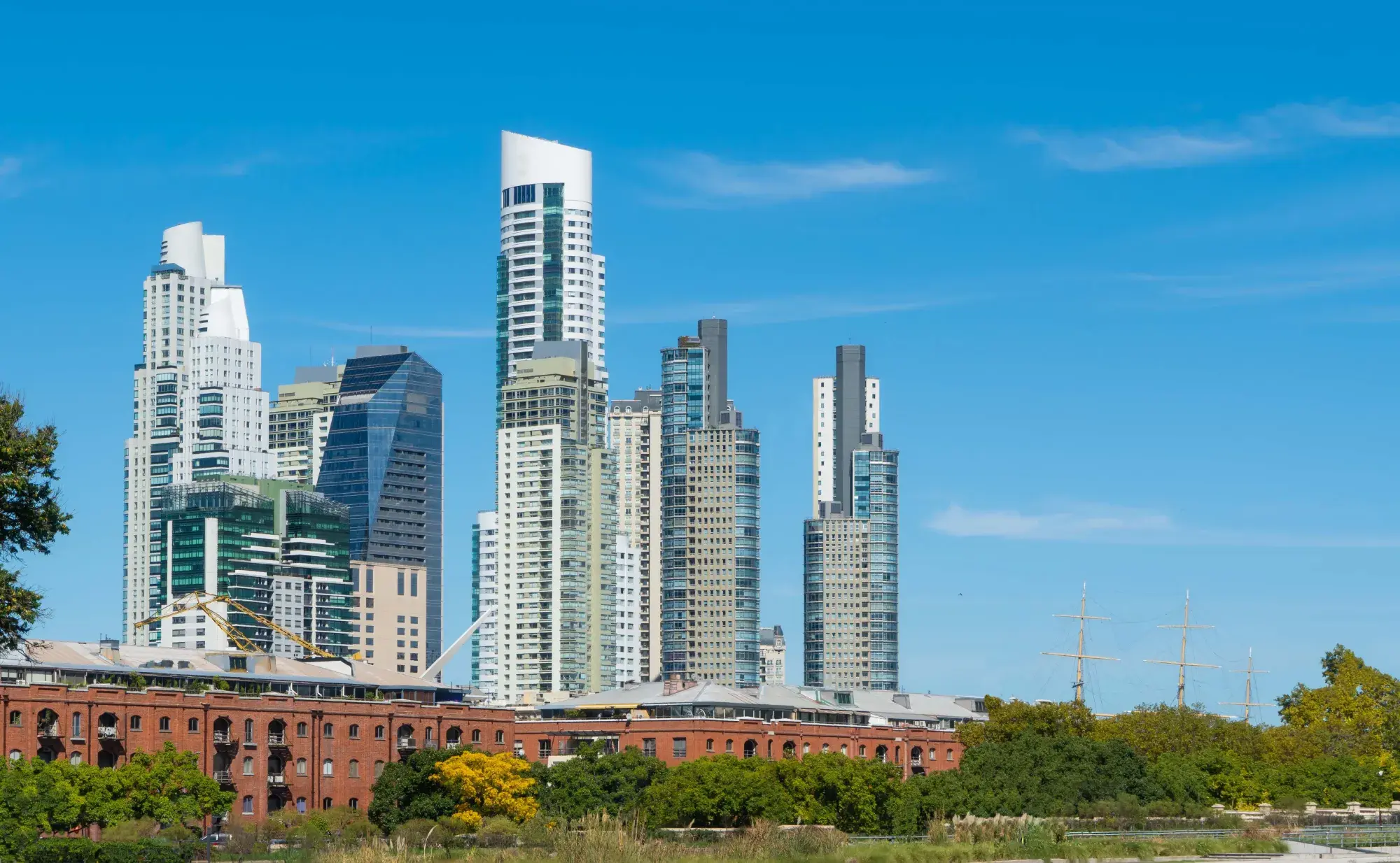 Waterfront skyline with modern glass towers rising behind historic brick warehouse buildings